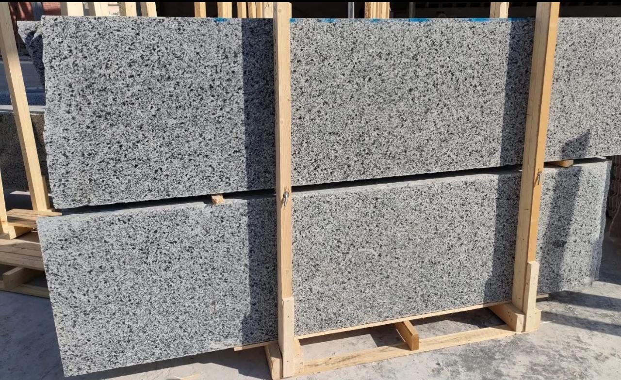 Grey granite slabs on a wooden rack